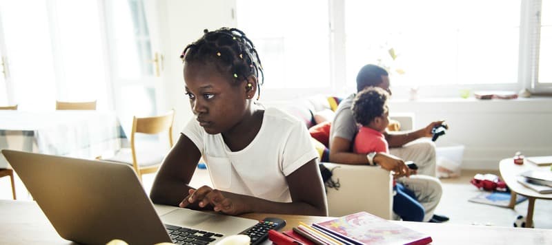 Black girl using laptop at home