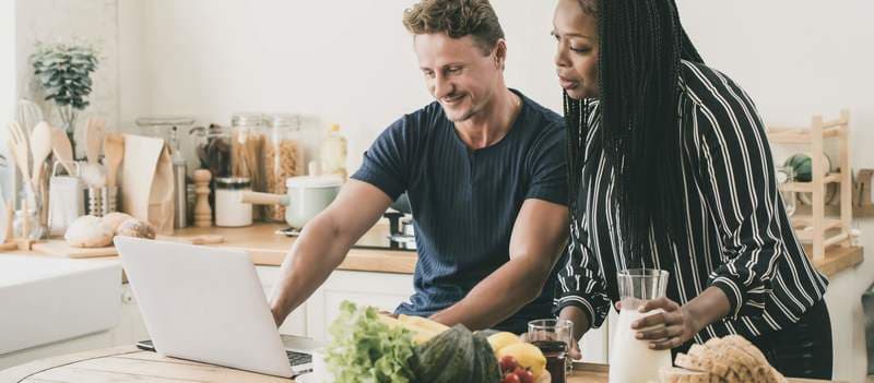 Multi-ethnic couple having a breakfast while working at home